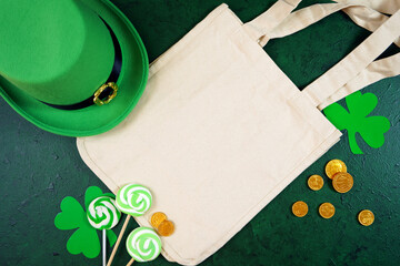 Happy St Patrick's Day natural canvas tote bag, styled with leprechaun hat, shamrocks, and...
