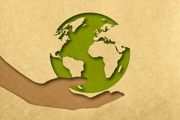 The silhouette of the planet in the arms of the hands in the style of paper clippings. Ecological concept. The green planet. Earth Day. Mother Nature. Recycling. Biodegradable material.