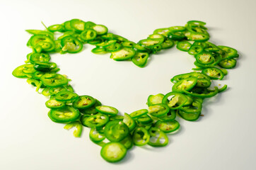 Fresh sliced green jalapeno peppers on a white background, spicy flavor ingredient in many dishes