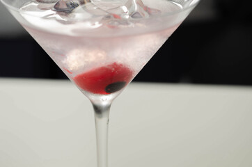 Halloween drink in a martini glass based on vodka, cream liqueur and grenadine with an edible decorative element in the shape of an eye