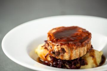 Home made steak and ale pie with homemade shortcrust pastry topped with gravy on a bed of mash