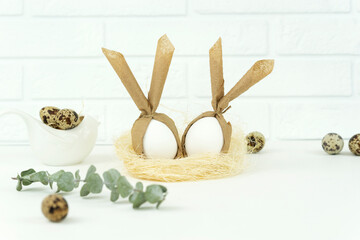 Funny Easter eggs lie in a straw nest as a decoration for happy hollidays..