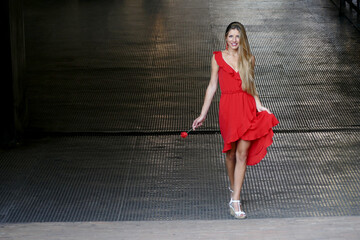 Bellissima ragazza bionda sorridente con vestito rosso