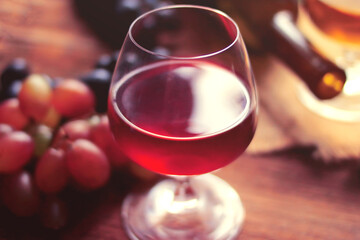 Glass of wine, bottle, grapes on a background of boards.