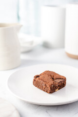 Chocolate cake on a plate with a white colour palette