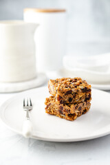 Two pieces of flapjack on a white plate - contemporary vibe