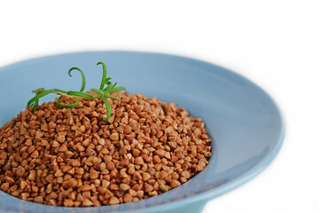 Buckwheat in a blue plate on a white background.Healthy food.