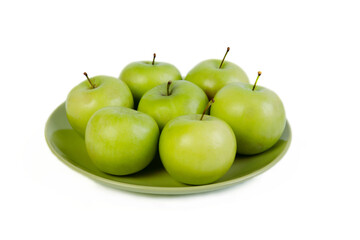 green apples on a plate of isolate