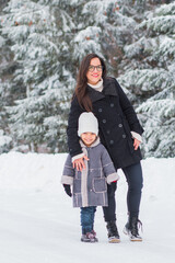 Fototapeta na wymiar authentic portrait of a young mother and daughter in the snow