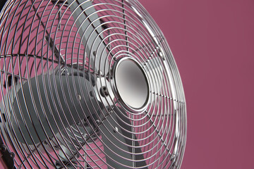 Modern electric fan on pink background, closeup
