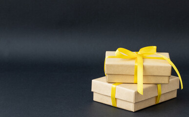 Holiday gift boxes with yellow ribbon on black background