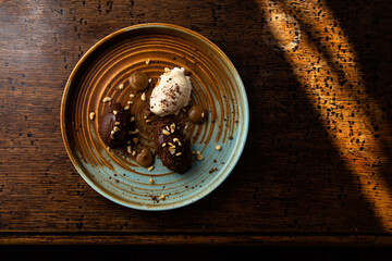 Chocolate, white chocolate and caramel ice cream quenelles on a colourful, rustic plate