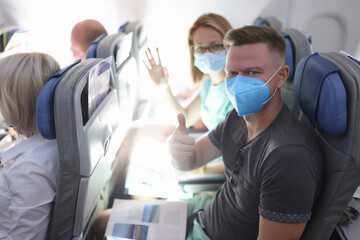 Fototapeta na wymiar Man and woman in medical protective masks on plane. Safe flying in coronavirus pandemic concept