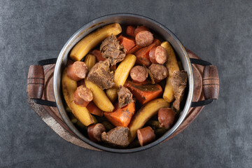 Black iron pan with cooked Brazilian food top view