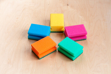 five colorful sponges on wooden background