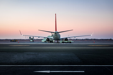 Fototapeta na wymiar airplane standing on the airport runway at sunset