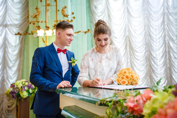 Newlyweds sign a document at the registry office