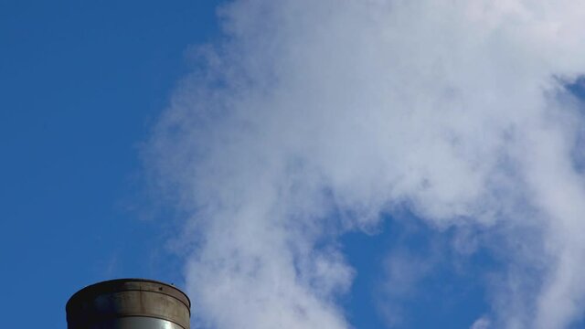 fluffy white smoke on factory industrial chimney heating coal power Plant blue sky air pollution close up
