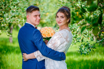 The bride and groom are walking their backs in the forest and admire nature and look at the landscape. Wedding ceremony and photo shoot outdoors. Newlyweds. Rear view.