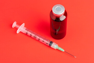 Disposable Syringe Injection And Amber Color Vial On Red Background