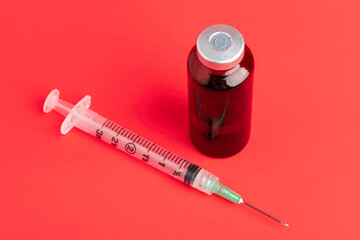 Disposable Syringe Injection And Amber Color Vial On Red Background