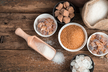 Cane, refined, crystalline sugar on a wooden background. Top view with copy space. The concept of a grocery background.