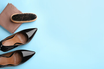 Flat lay composition with shoe care accessories and footwear on light blue background. Space for text