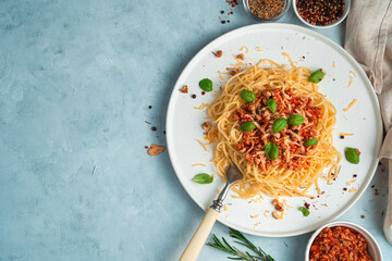 Culinary background with spaghetti and bolognese sauce on a blue-gray background. Top view with copy space. The concept of cooking.