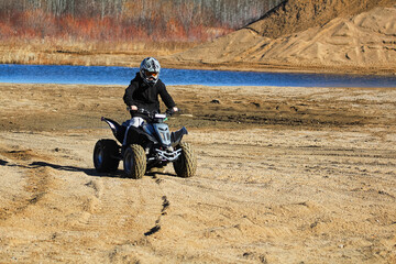 A young boy driving his atv in a sand quarry © Amelia