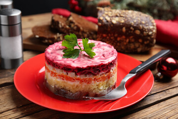 Herring under fur coat served on wooden table, closeup. Traditional russian salad