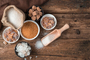 Many types of sugar on a wooden background. Top view with copy space. The concept of a grocery background.