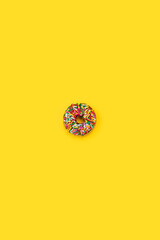 rainbow sprinkle donut isolated on yellow