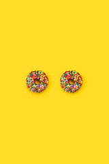 chocolate sprinkle donuts on yellow background