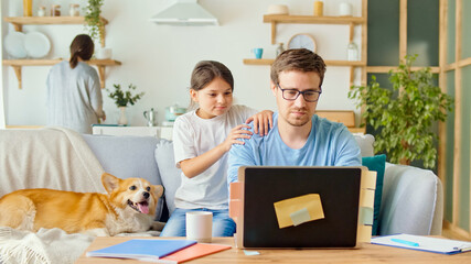 Social Distancing. A Busy Father Tries to Work Remotely with His Child and Wife at Home. The...