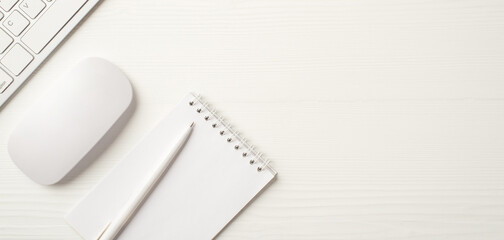 Workplace of business person concept. Overhead close up view photo of white keyboard computer mouse paper copybook with pen isolated wooden backdrop with empty space