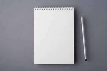 Above overhead close up view photo of clear notepad with place for design and pencil isolated grey color desk desktop