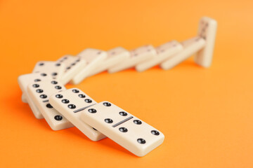 White domino tiles falling on orange background