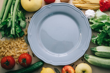 pasta and tomatoes, vegetables on a beige background, bay leaf. in the middle of the plate is gray