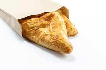 Homemade appetizing puff pastry pies on a paper bag