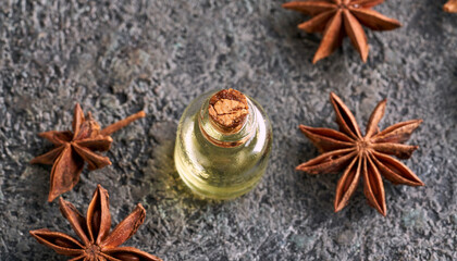 A bottle of star anise essential oil with dried star anise