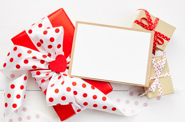 Valentines day greeting card mockup, gift boxes and red heart on white wooden background