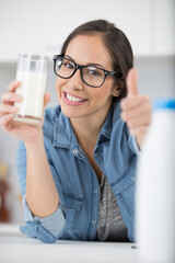 woman drinking a glass of milk happy with thumb up