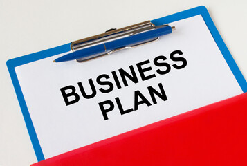 Clipboard with text Business Plan blue pen and red folder