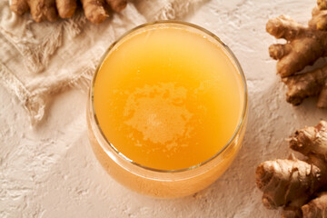 A glass of ginger probiotic drink on a white background