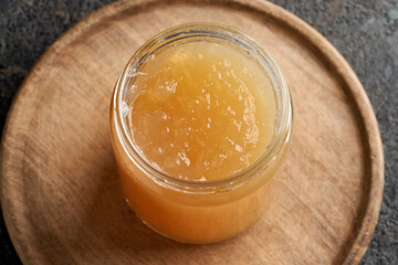 Cold congealed beef bone broth in a glass jar on a table