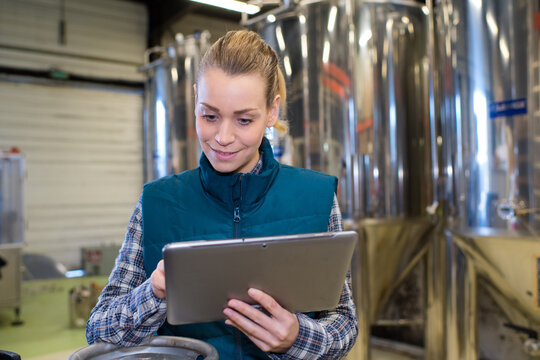 smiling female worker using digital tablet in manufacturing industry