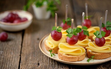 Canapes made from rye bread, cheese and organic grapes. 