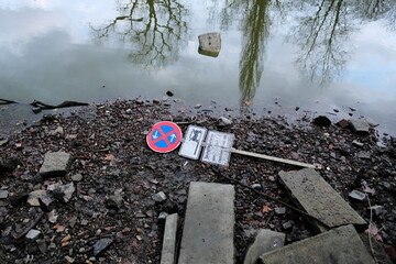 Polluted lake with garbage and road sign