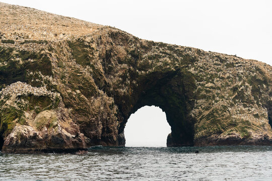 Natural arch over sea against clear sky at Ballestas Islands, Paracas, Peru