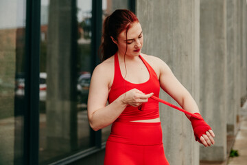 Young female boxer, wrapping wrist for boxing in Brooklyn street.